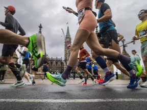 Marathon runners make their way past Parliament Hill during the first couple kilometres of their race.