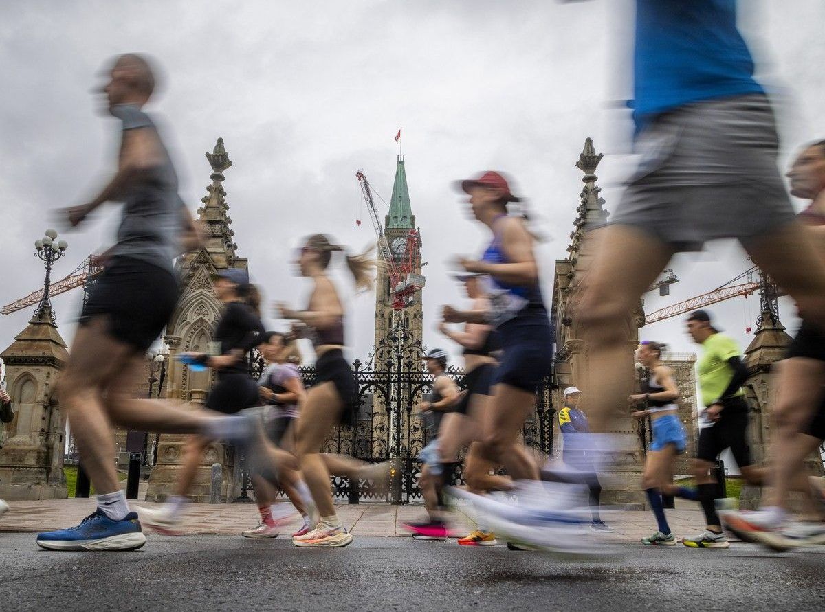  Marathon runners make their way past Parliament Hill during the first couple of kilometres of their race Sunday.
