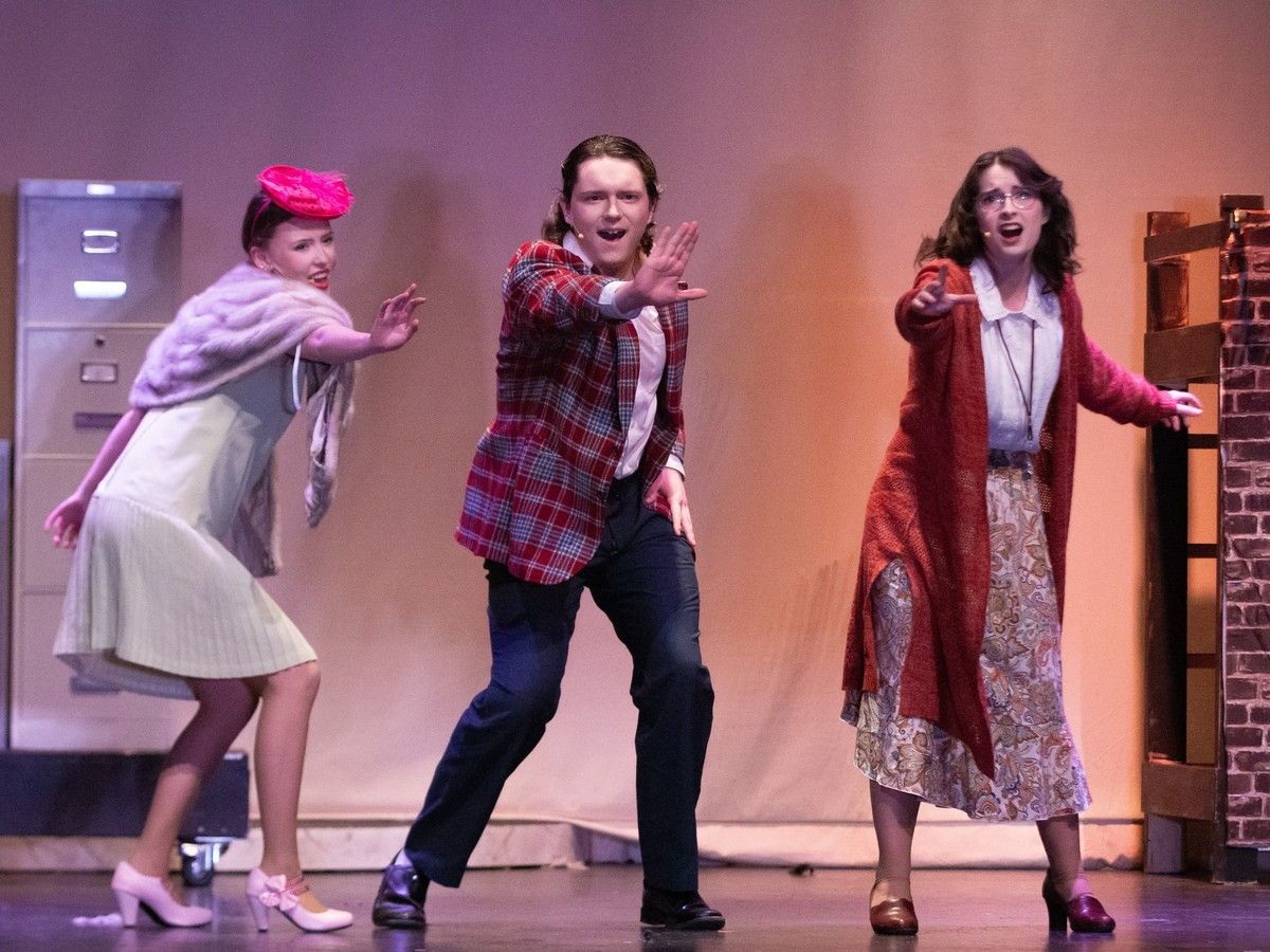 Sophie Carriere performs as Lily St Regis (L), Alexander Peddle performs as Rooster Hannigan, Emily Poitras performs as Miss Hannigan (R), in St. Mother Teresa's production of Annie