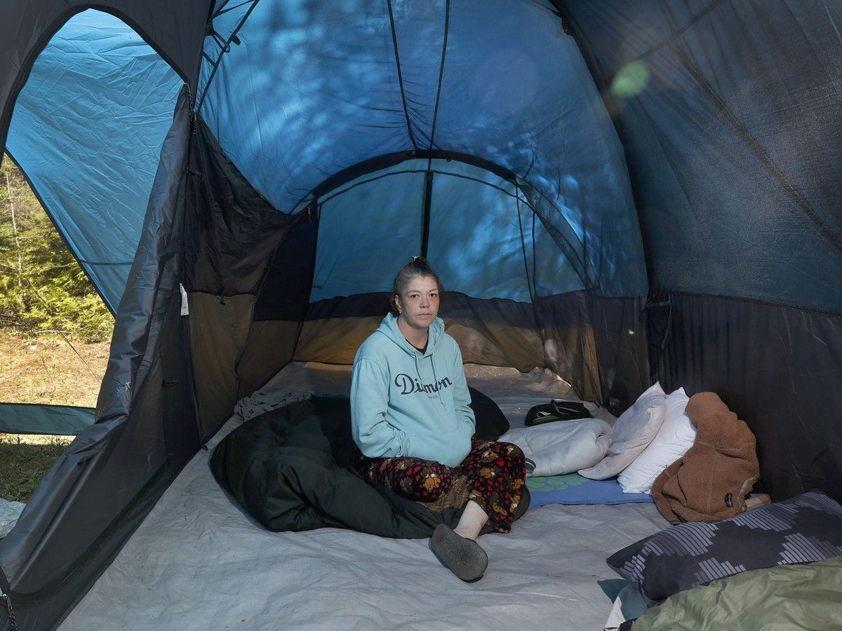  Amy Ayers sits inside her tent in a forest outside of Ottawa Thursday. Ayers and her three children, aged 26, 15 and 14 are homeless and are living in a tent in the forest while they seek permanent housing.