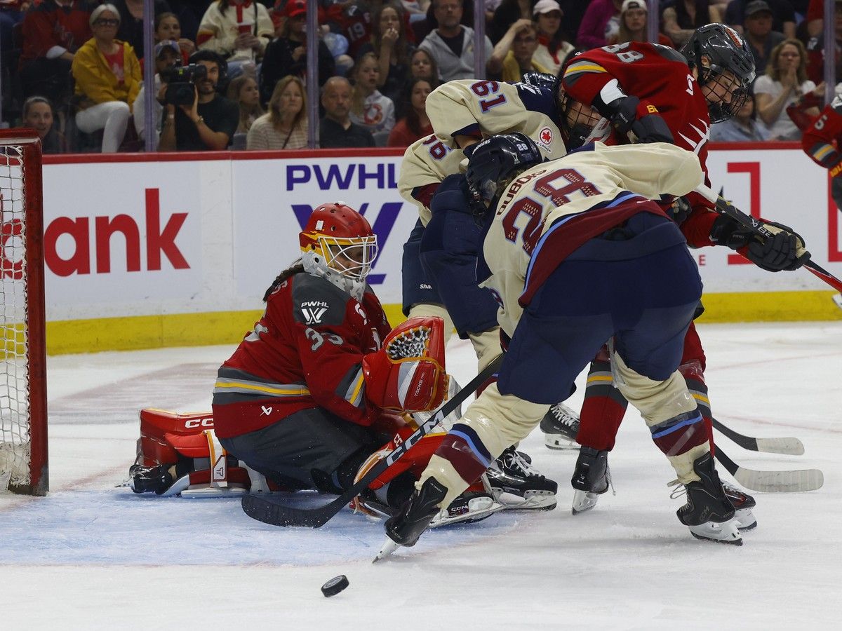 Ottawa Charge goalie Gwyneth Philips watches Catherine Dubois from the Montreal Victoire miss the puck