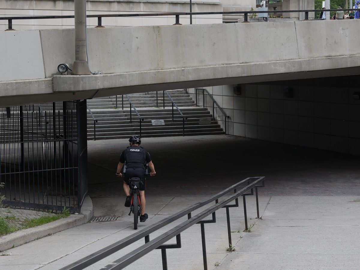 An Ottawa police officer rides his bike near the Circle close to the pedestrian underpass bridge near the intersection of Rideau Street and Sussex Drive.