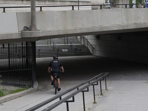 An Ottawa police officer rides his bike near the Circle close to the pedestrian underpass bridge near the intersection of Rideau Street and Sussex Drive.