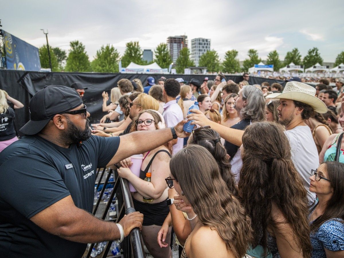 Security staff handed out bottles of water to fans at the front of the RBC Stage during Ottawa Bluesfest at LeBreton Flats as temperatures climbed on Sunday, July 12, 2026. Security staff handed out bottles of water to fans at the front of the RBC Stage during Ottawa Bluesfest at LeBreton Flats as temperatures climbed on Sunday, July 12, 2026.