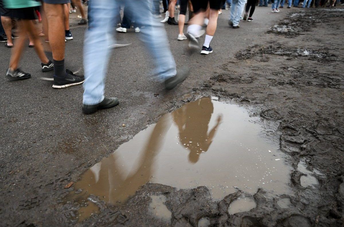 People walk along the pavement next to a large mud puddle at the Ottawa Bluesfest at LeBreton Flats on Thursday, July 9, 2026. People walk along the pavement next to a large mud puddle at the Ottawa Bluesfest at LeBreton Flats on Thursday, July 9, 2026.