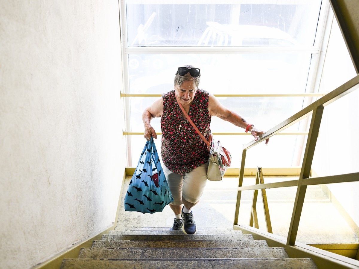  Christina Grosskleg climbs up a flight of stairs as she carries groceries to her McEwen Avenue apartment following severe flooding and thunderstorms July 1.