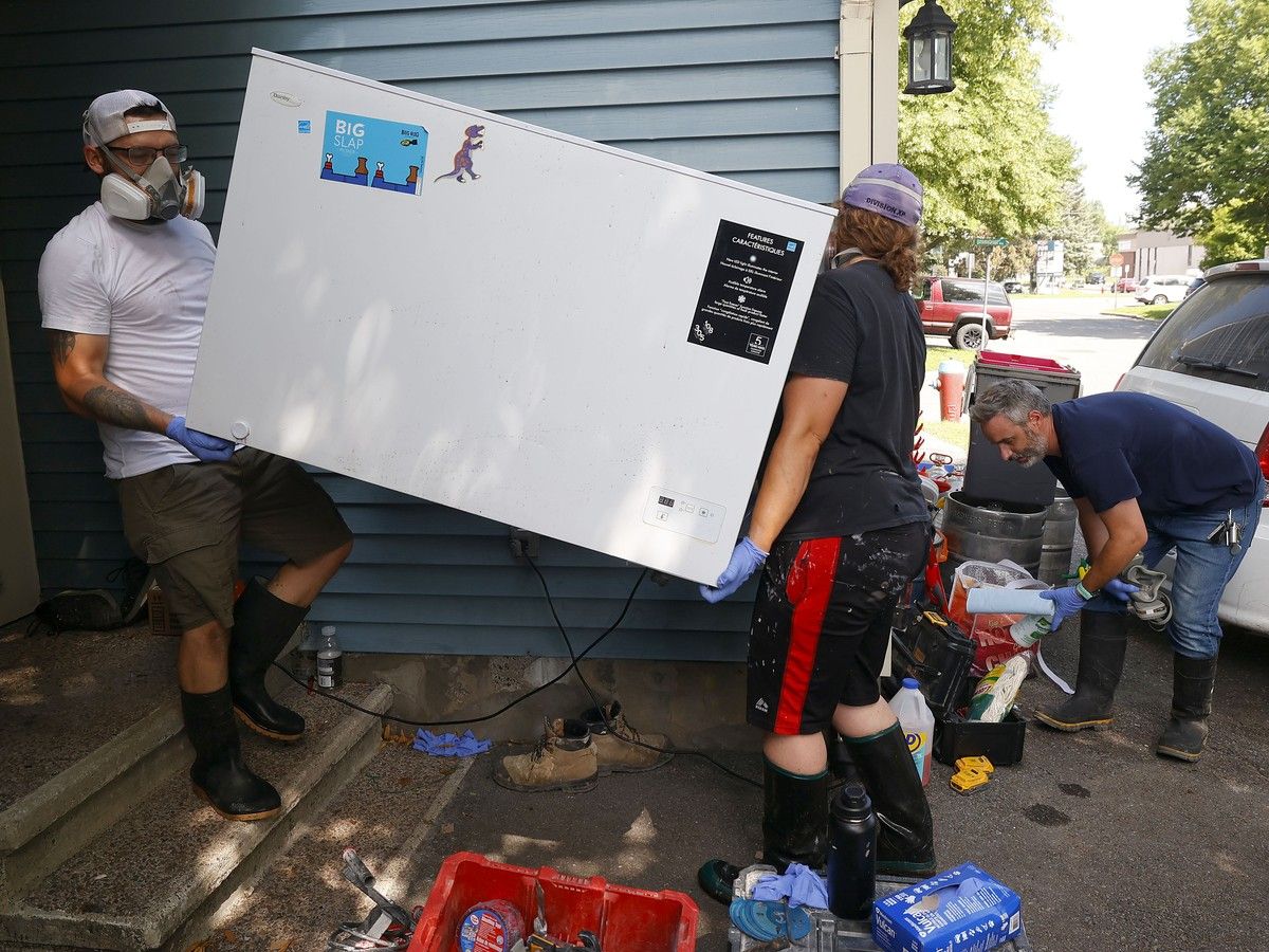 Homeowner Benjamin Borg (right) and a crew take out damaged items from his flooded basement on Saxton Private in Ottawa Tuesday. Sewage water destroyed everything in his basement during the flooding July 1. Homeowner Benjamin Borg (right) and a crew take out damaged items from his flooded basement on Saxton Private in Ottawa Tuesday. Sewage water destroyed everything in his basement during the flooding July 1.