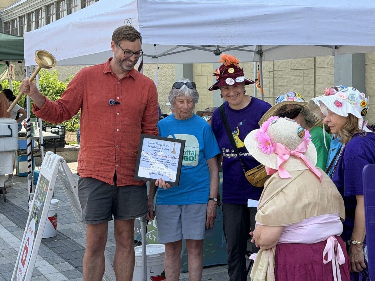  Capital ward Coun. Shawn Menard is pictured with GottaGo! co-founder Bessa Whitmore and other volunteers on Sunday, July 12, 2026, after he was recognized with the Golden Plunger award for his advocacy efforts in expanding washroom access both within his ward and across the city.