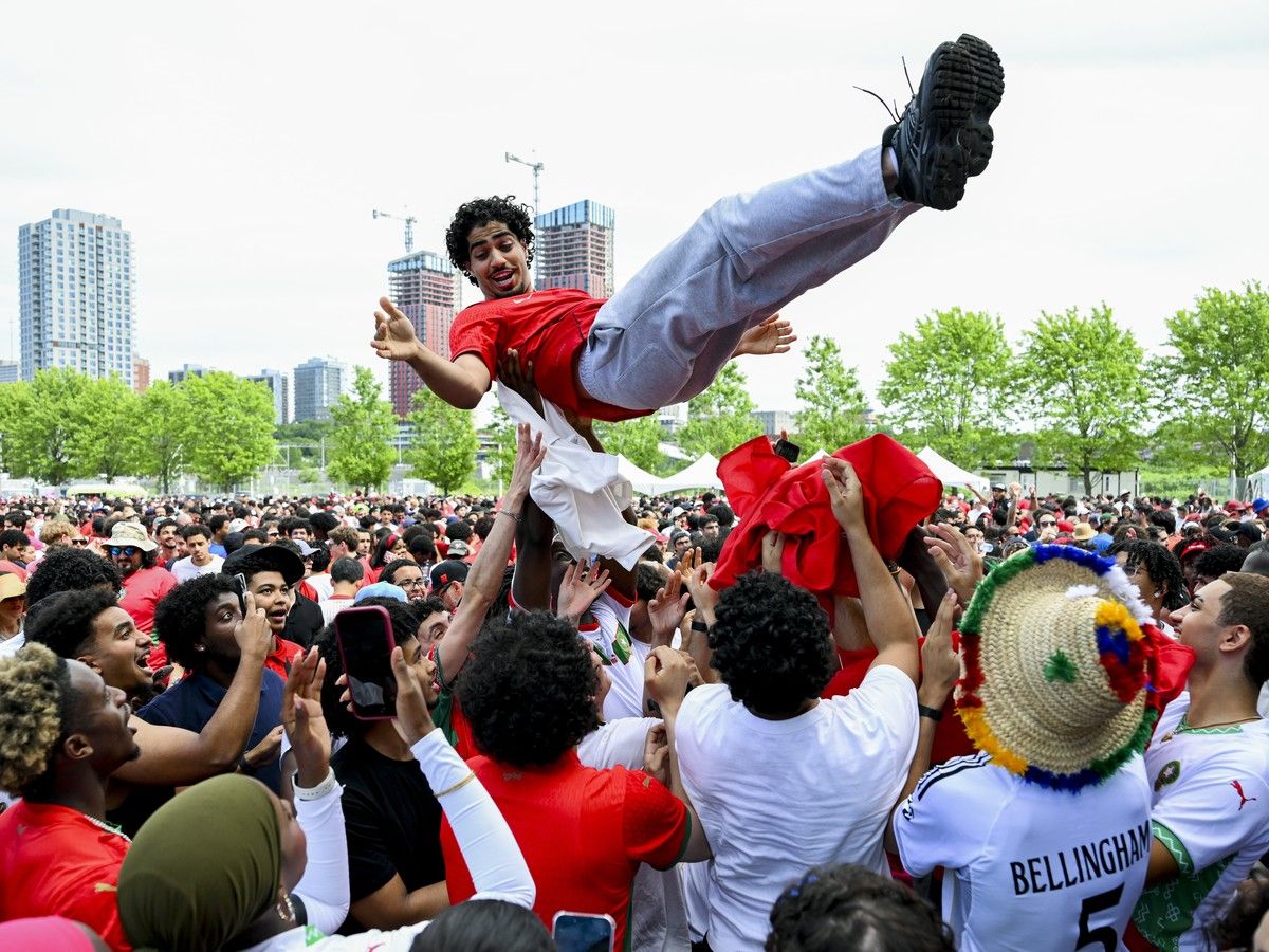 Moroccan fans lift a fan wearing a Canadian jersey into the air following Morocco’s victory over Canada. Moroccan fans lift a fan wearing a Canadian jersey into the air following Morocco’s victory over Canada.