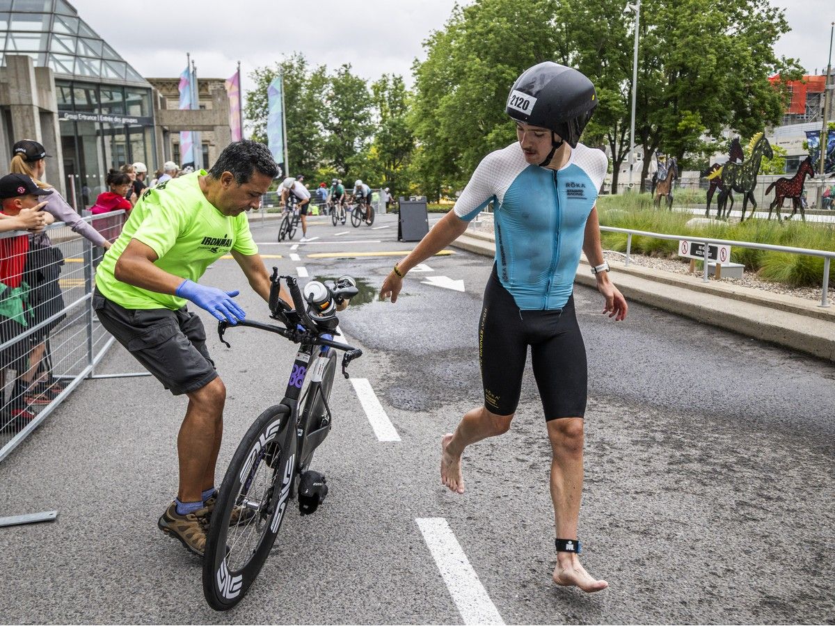Racers pass their bikes off to volunteers as they transition to the run portion of the three-part event. Racers pass their bikes off to volunteers as they transition to the run portion of the three-part event.