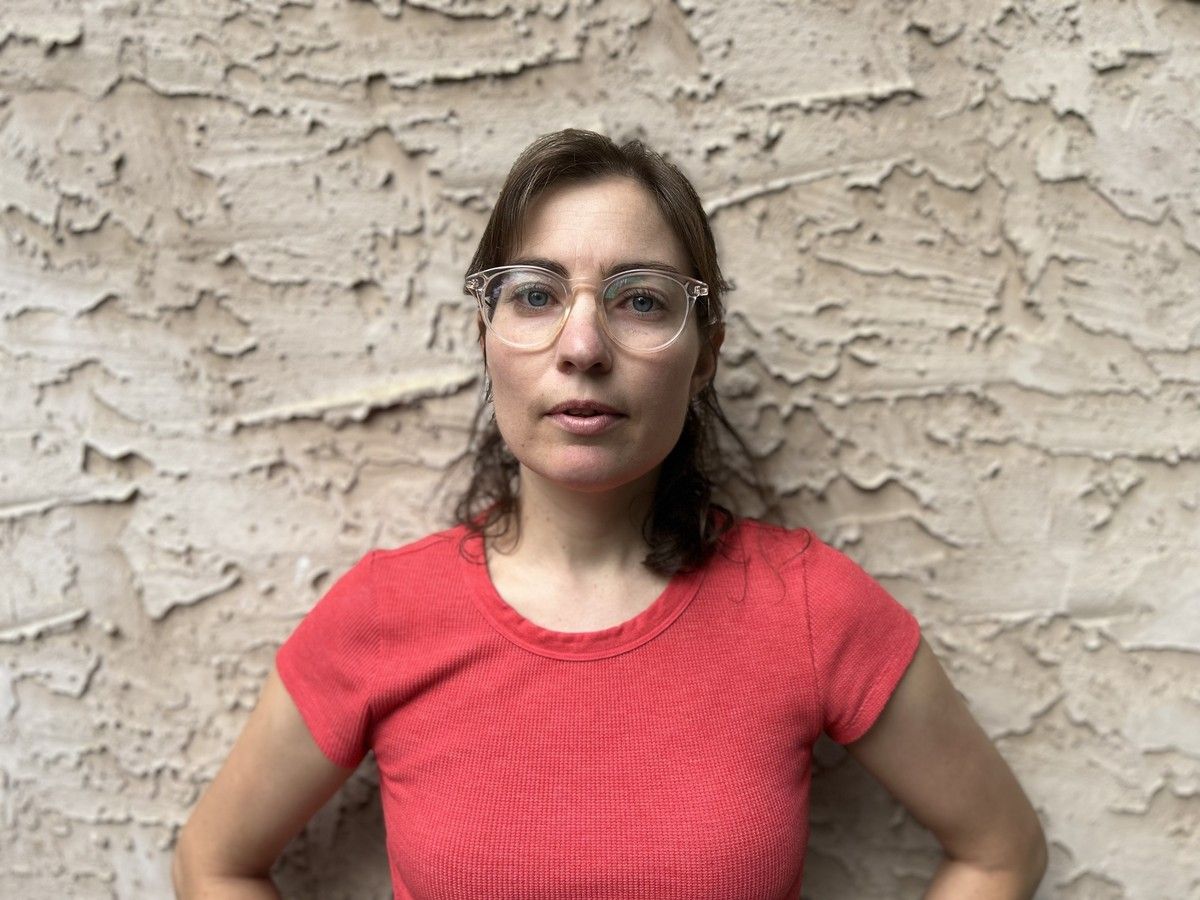A woman in a pink shirt poses for a photo.