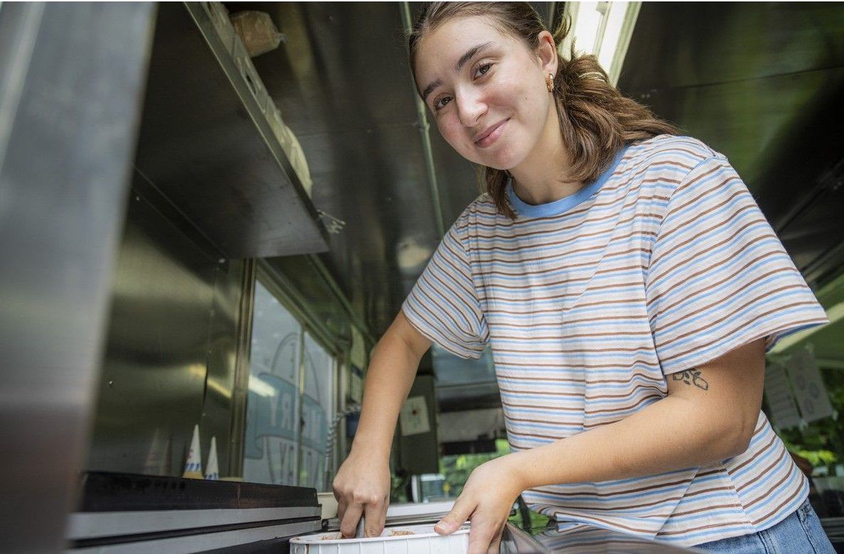 Reporter Olivia Belovich scoops up some ice cream for a customer at the Merry Dairy pop-up event at Frank Ryan Park on Aug. 1. Reporter Olivia Belovich scoops up some ice cream for a customer at the Merry Dairy pop-up event at Frank Ryan Park on Aug. 1.