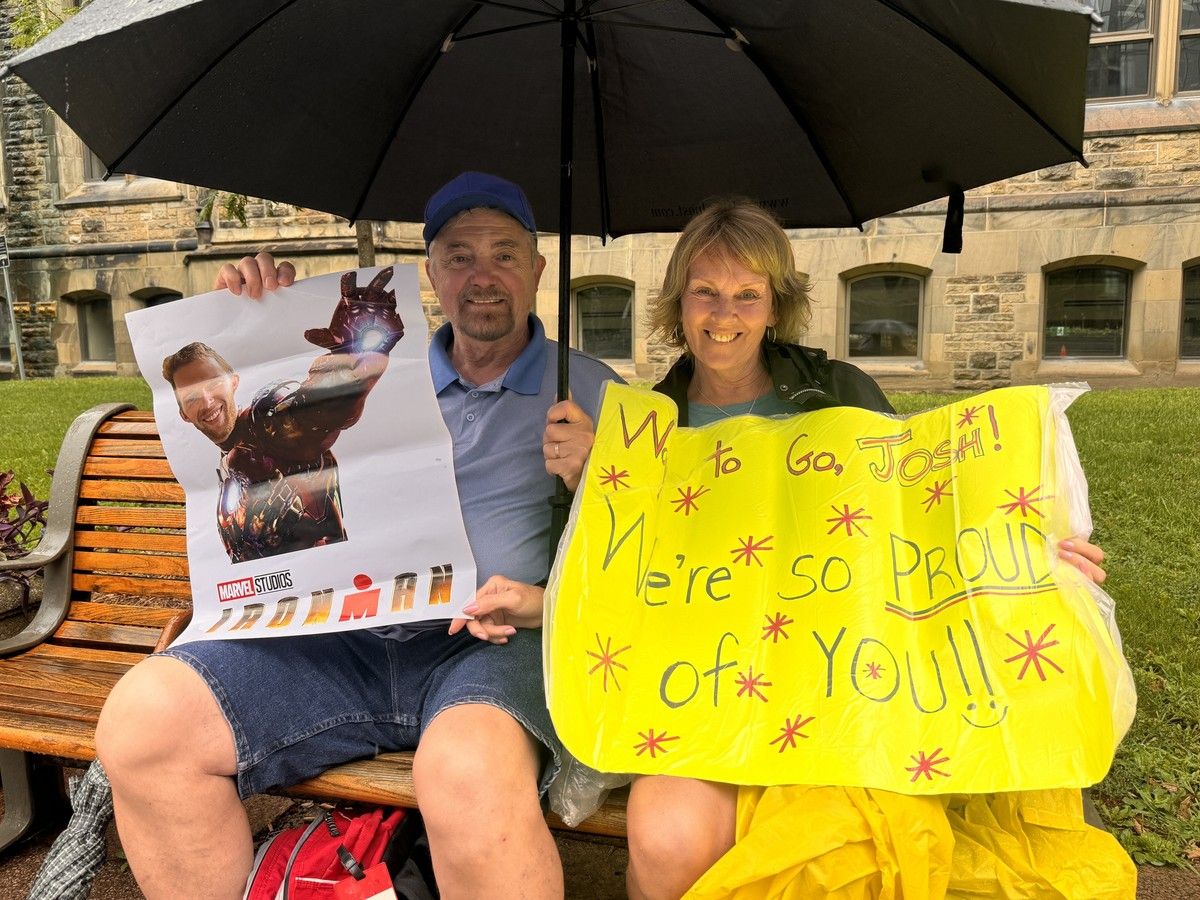 Vic Chimienti and Cate Collins from Belleville hold up signs in front of the Confederation Building while waiting for their 30-year-old nephew, Josh Collins, to run by. Vic Chimienti and Cate Collins from Belleville hold up signs in front of the Confederation Building while waiting for their 30-year-old nephew, Josh Collins, to run by.