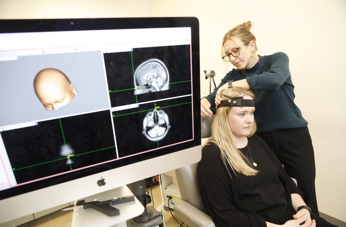  Research co-ordinator and rTMS technician Rosalie L&eacute;tourneau, right, demonstrates rTMS on her colleague, Jessica Drodge, staff interventional psychiatry research co-ordinator at The Royal.