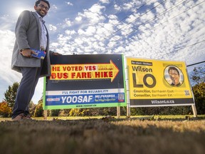 Yoosaf Melparamba, a candidate for councillor in Ward 24, is photographed with his campaign signs along Woodroffe Ave. in Barrhaven