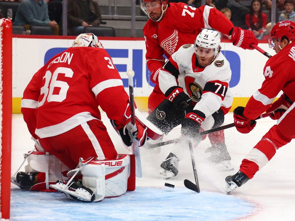 Ridly Greig of the Ottawa Senators tries to get a shot off in front of goalie John Gibson of the Detroit Red Wings during the first period at Little Caesars Arena on Tuesday, Oct. 6, 2026, in Detroit.