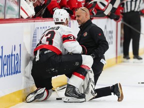 Nikolas Matinpalo of the Ottawa Senators is attended to by a trainer after being hit by Anthony Mantha of the New Jersey Devils (not pictured) during the first period at the Prudential Center on Monday night.