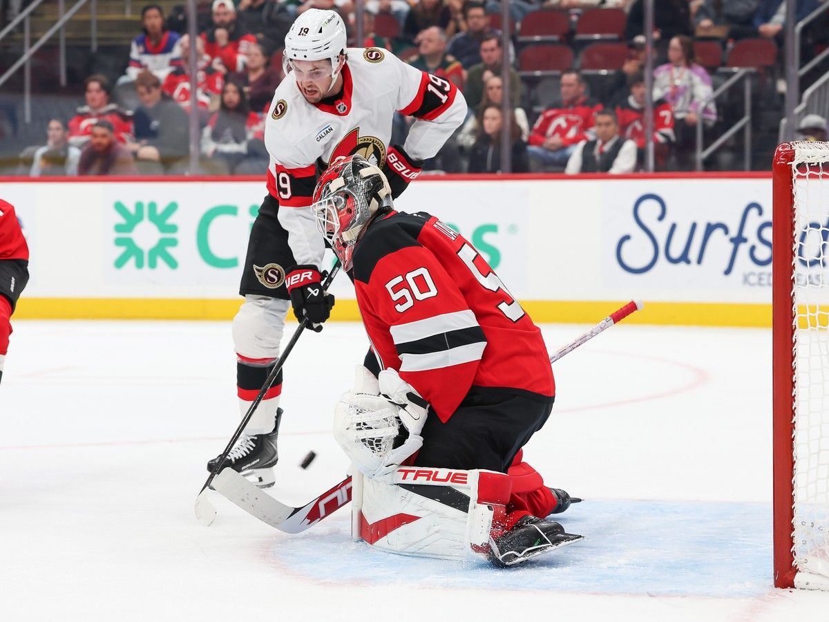 Nico Daws of the New Jersey Devils makes a save with the Ottawa Senators' Drake Batherson in front of the net during the first period at the Prudential Center on Monday night.