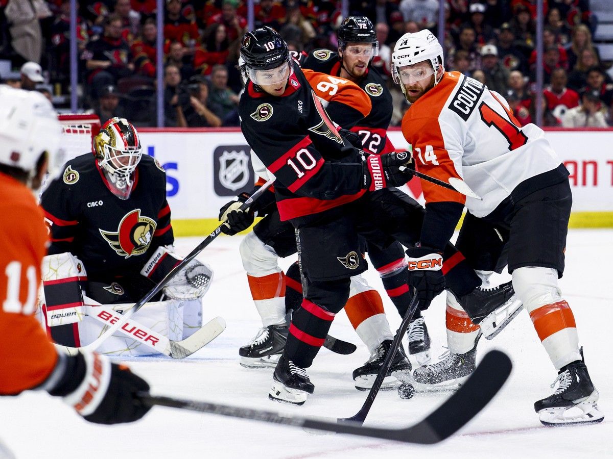 The Ottawa Senators' Jordan Spence and the Philadelphia Flyers' Sean Couturier look for the puck as goalie Linus Ullmark looks on Thursday night.
