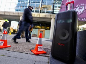 A speaker plays music as striking Bank of Canada workers walk a picket line outside Bank of Canada's Sparks Street entrance .