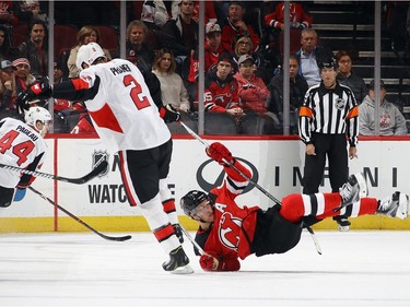 Senators defenceman Dion Phaneuf body checks Taylor Hall of the Devils during the first period.  Bruce Bennett/Getty Images
