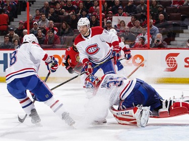 Al Montoya of the Canadiens attempts to cover the puck with his trapper as Jordie Benn (8) and Shea Weber (6) look on in the second period.  Jana Chytilova/Freestyle Photography/Getty Images