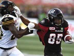 Ottawa Redblacks' Diontae Spencer (85) fends off Hamilton Tiger-Cats' Demond Washington (24) during the first half of a CFL football game in Ottawa on Saturday, Sept. 9, 2017.