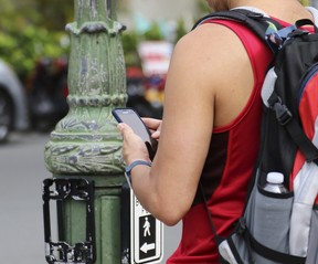 A man uses his cellphone before crossing a street in Honolulu on Wednesday, Oct. 25, 2017.