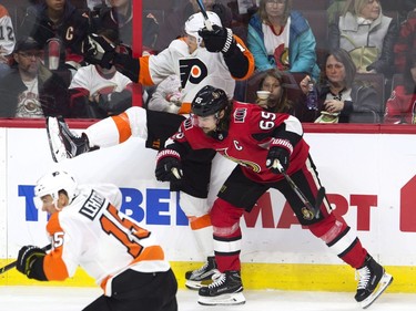 Ottawa Senators defenceman Erik Karlsson sends Philadelphia Flyers centre Travis Konecny into the boards.