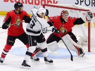 Ottawa Senators goalie Mike Condon makes a glove save as Senators defenceman Cody Ceci, left, and Los Angeles Kings right wing Dustin Brown look on during first period NHL action in Ottawa on Tuesday October 24, 2017. THE CANADIAN PRESS/Sean Kilpatrick