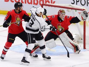 Ottawa Senators goalie Mike Condon makes a glove save as Senators defenceman Cody Ceci, left, and Los Angeles Kings right wing Dustin Brown look on during first period NHL action in Ottawa on Tuesday October 24, 2017. THE CANADIAN PRESS/Sean Kilpatrick