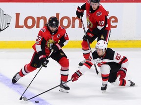 Ottawa Senators defenceman Erik Karlsson fights for the puck against New Jersey Devils left wing Jesper Bratt during second period NHL action in Ottawa on Thursday, October 19, 2017.