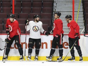 A quartet of Senators players take a break along the boards during practice at Canadian Tire Centre on Monday. Jean Levac/Postmedia