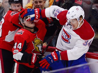 Canadiens right winger Michael McCarron shoves his glove in the face of Senators centre Jean-Gabriel Pageau. (CP)