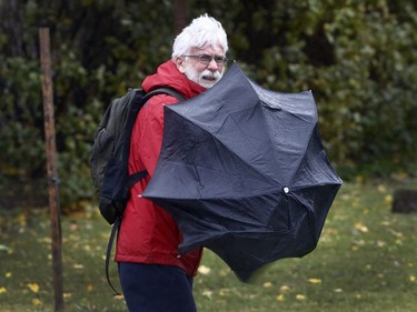 A man fights the wind and rain walking down Riverside Drive in Ottawa Monday Oct. 30, 2017.
