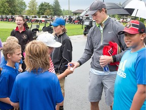 Kyle Turris signs autographs for kids taking part in a golf camp.