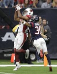 Arizona Cardinals wide receiver Larry Fitzgerald  pulls in a catch for a touchdown over Houston Texans cornerback Kevin Johnson on Sunday. (AP PHOTO)