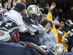 Saints' Alvin Kamara jumps into the stands after scoring a touchdown against Washington yesterday. (GETTY IMAGES)