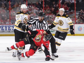 NHL linesman and Carp native Derek Nansen separates Senators’ Clarke MacArthur and Boston’s Joe Morrow. (GETTY IMAGES)