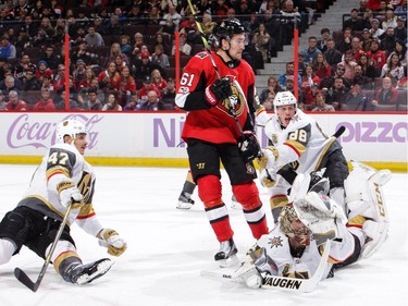 Maxime Lagace #33 of the Vegas Golden Knights makes a desperate dive to get the puck on a shot by Mark Stone #61 of the Ottawa Senators as Luca Sbisa #47 and Nate Schmidt #88 of the Vegas Golden Knights defend.