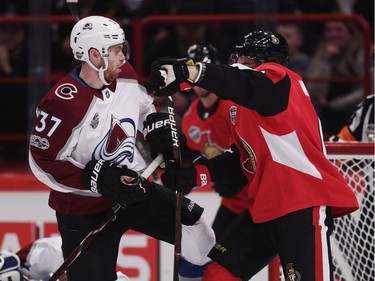 J.T. Compher of Colorado Avalanche gets tangled up with Chris Wideman of Ottawa Senators.