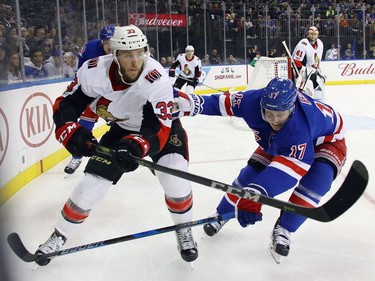 Fredrik Claesson #33 of the Ottawa Senators pushes the puck away from Jesper Fast #17 of the New York Rangers during the second period at Madison Square Garden on November 19, 2017 in New York City.  (Photo by Bruce Bennett/Getty Images)