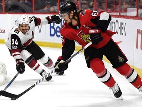 Ottawa Senators' Erik Karlsson skates with the puck as Arizona Coyotes' Zac Rinaldo tries to poke it away on Nov. 18, 2017