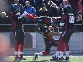 Redblacks receiver Greg Ellingson does a limbo under Diontae Spencer as Juron Criner (86) and Dominique Rhymes (89) hold Spencer aloft after his first-quarter touchdown on Sunday. THE CANADIAN PRESS/Justin Tang