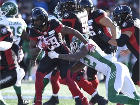 Redblacks tailback William Powell tries to fend off Roughriders defender Tobi Antigha during Sunday's playoff game in Ottawa. THE CANADIAN PRESS/Justin Tang