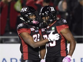 The Redblacks' Diontae Spencer, left, and William Powell celebrate a touchdown against the Ticats in the regular-season finale on Oct. 27. THE CANADIAN PRESS/Justin Tang