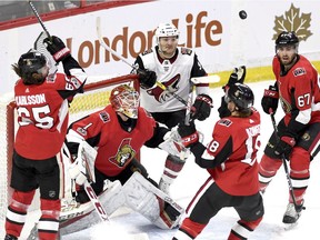 Ottawa Senators goaltender Mike Condon, Erik Karlsson, Ryan Dzingel, Ben Harpur and Arizona Coyotes' Christian Fischer watch the puck as it bounces in the air during second period NHL hockey action in Ottawa, Saturday Nov. 18, 2017. THE CANADIAN PRESS/Justin Tang