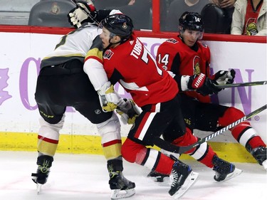 Ottawa Senators centre Kyle Turris (7) is held back by Vegas Golden Knights defenceman Brayden McNabb (3) as Senators right wing Alexandre Burrows (14) falls against the boards.