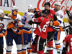 Senators defenceman Ben Harpur pushes with the Islanders' Scott Mayfield during the second period on Saturday, November 26.