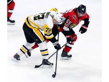The Pittsburgh Penguins' Patric Hornqvist (72) and the Ottawa Senators' Erik Karlsson (65) fight for possession of the puck.